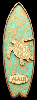 Decorative surfboard-shaped sign with a turtle design and 'Maui' text on a teal background.