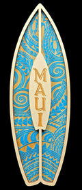 Decorative surfboard-shaped sign with blue and gold patterns and 'MAUI' text on a black background.
