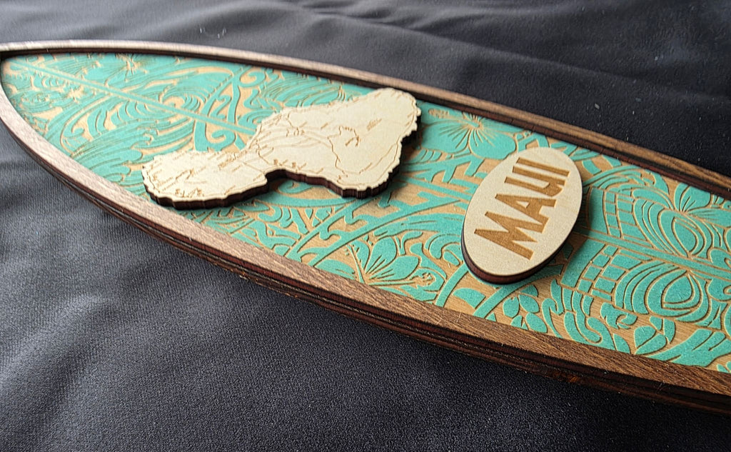 Decorative wooden sign with 'Maui' on a teal background