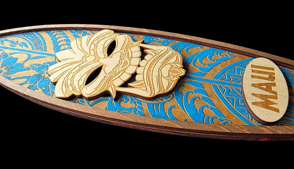 Decorative surfboard with gold and blue designs on a black background