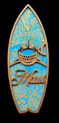 Decorative surfboard-shaped sign with shark design and 'Maui' text on a black background
