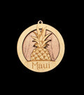 Wooden ornament with pineapple design and 'Maui' text on a black background