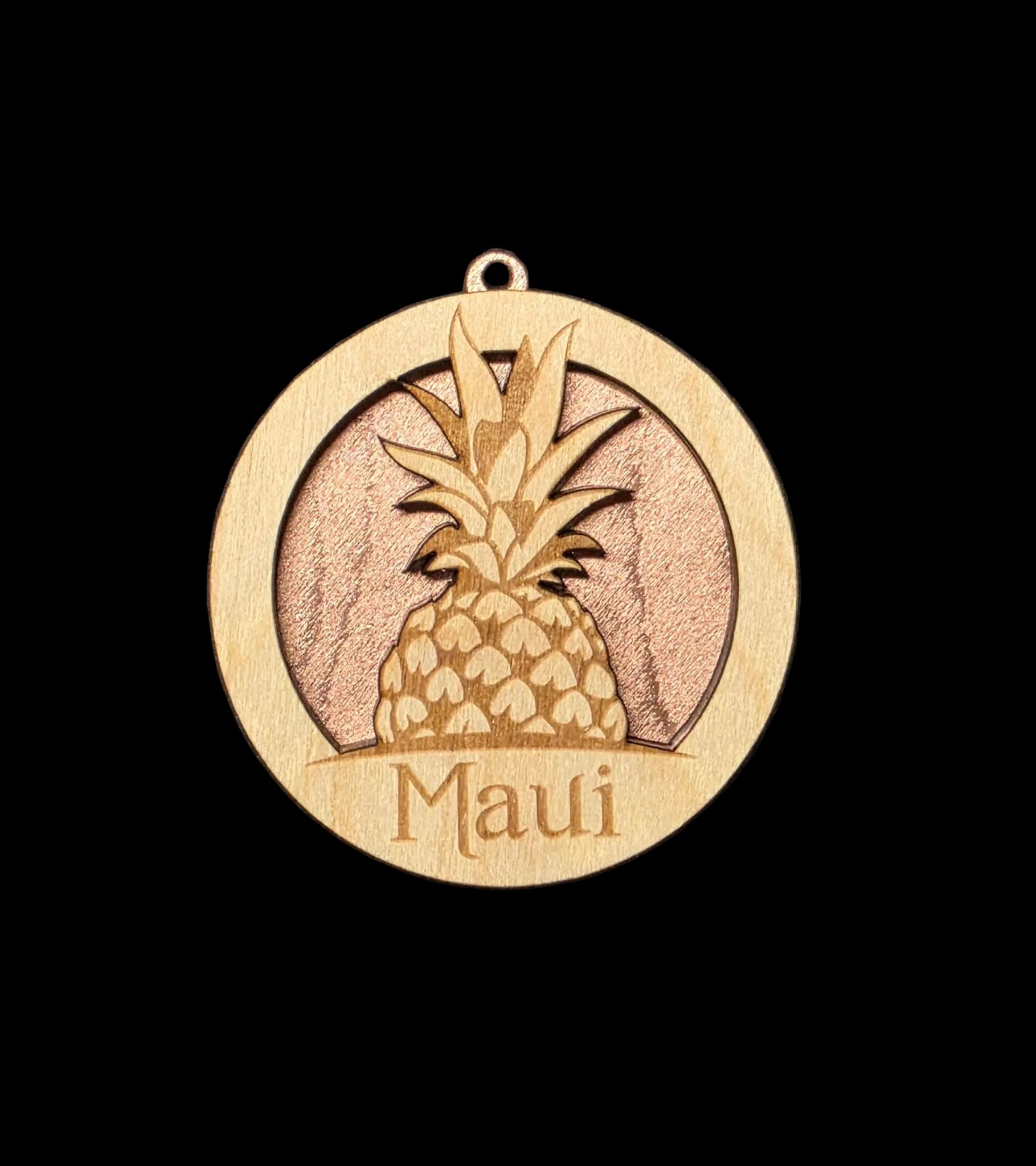 Wooden ornament with pineapple design and 'Maui' text on a black background