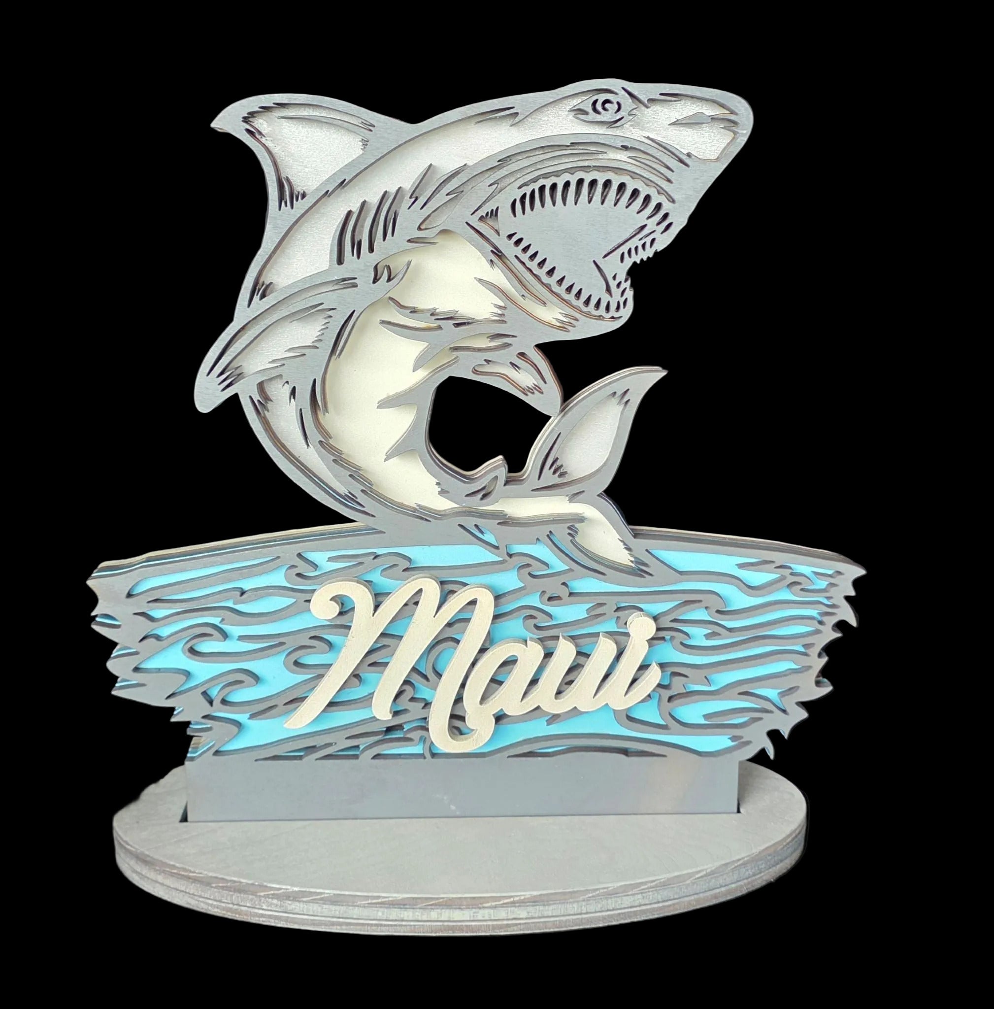 Decorative item with shark design and 'Maui' text on a dark background