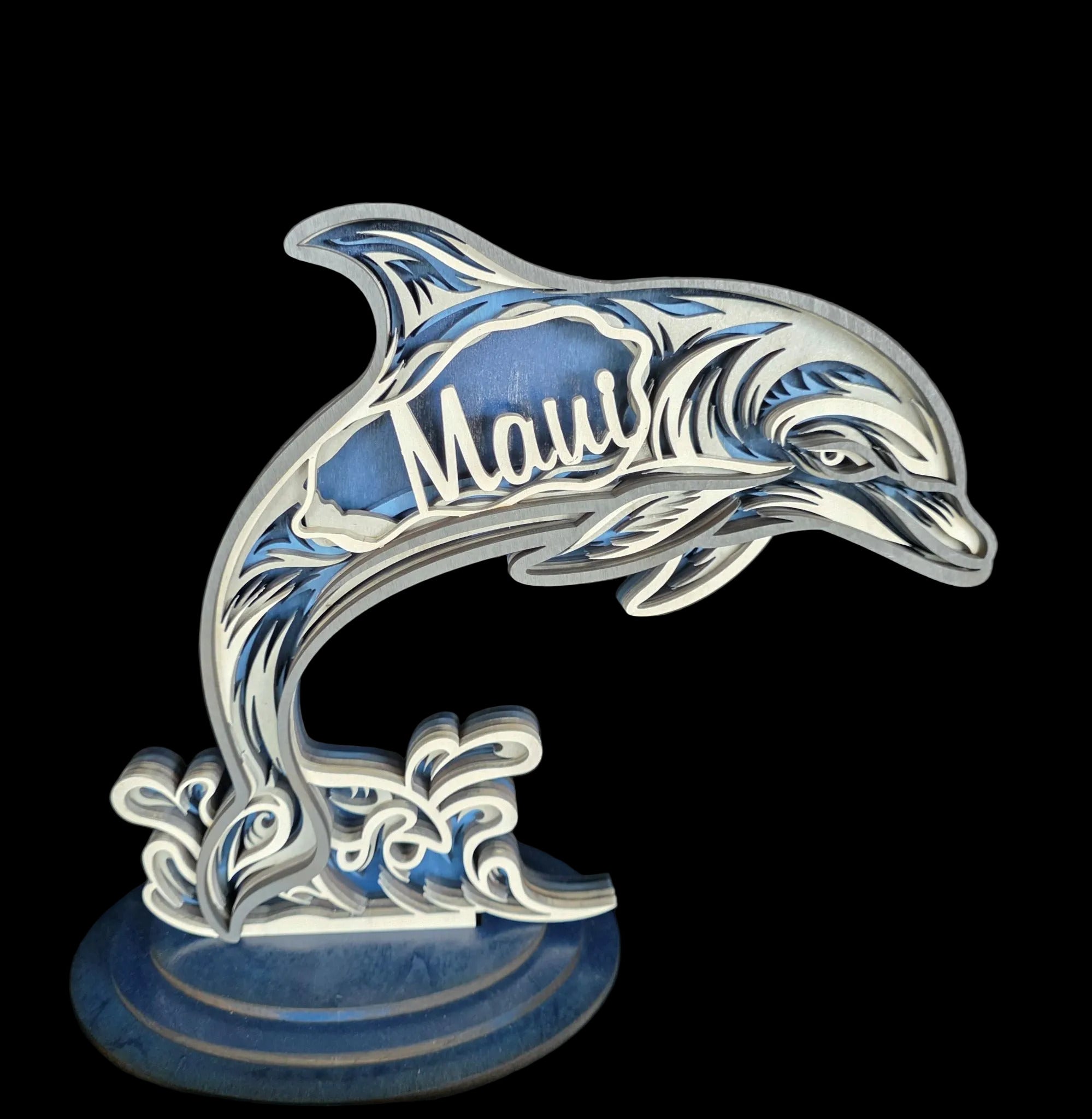 Decorative dolphin sculpture with 'Maui' on a dark background