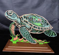 Wooden turtle sculpture on a stand against a dark background