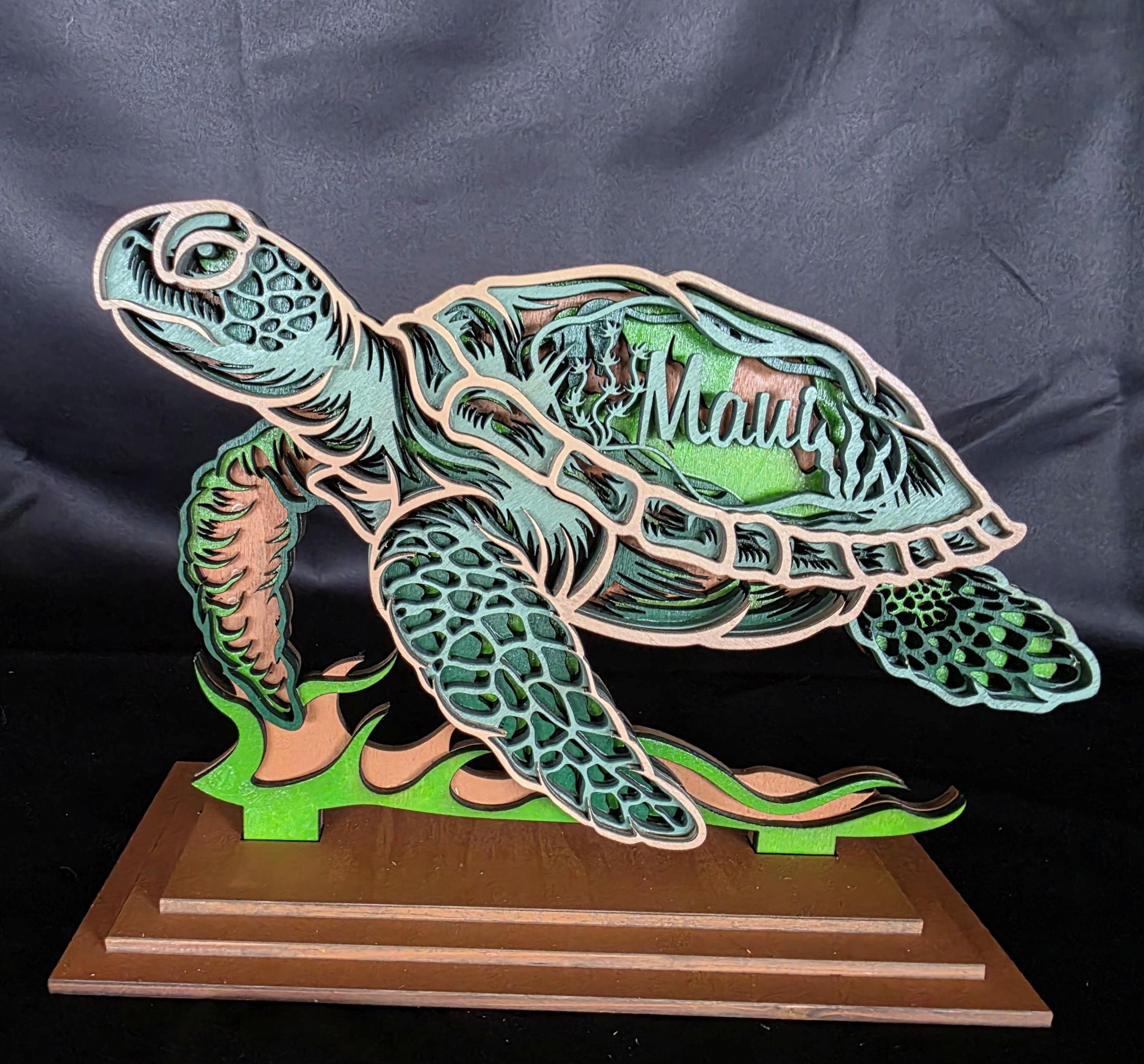 Wooden turtle sculpture on a stand against a dark background