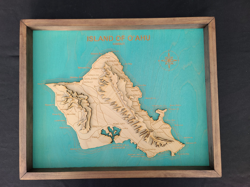 Wooden map of the Island of Oahu on a teal background with a wooden frame.