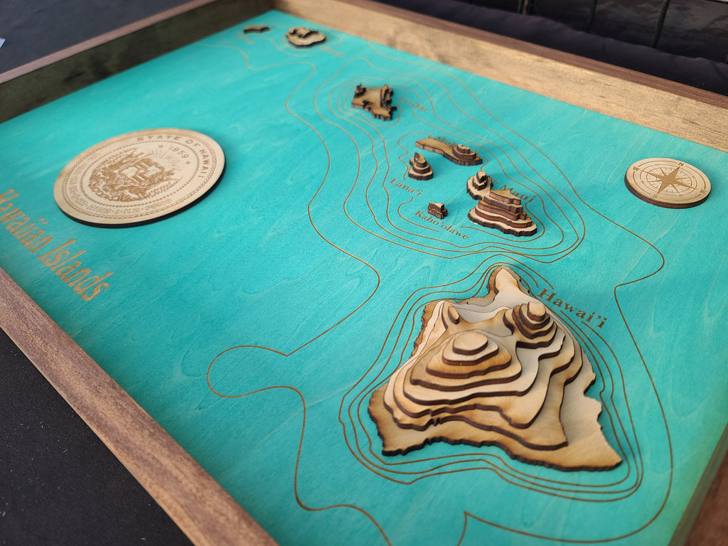 Wooden topographic model of a coastal area on a teal map background