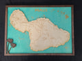 Wooden map of Maui with a teal background and wooden border